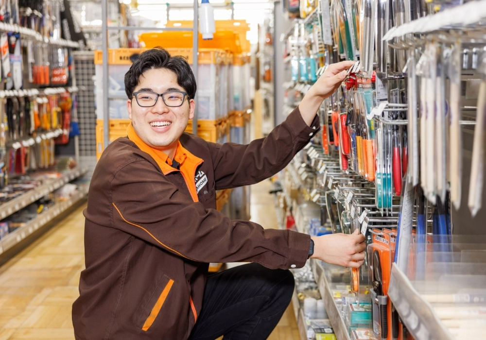 しゃがんで工具売場を整理するKさんの写真